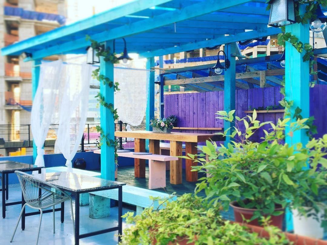 Gemütlicher Bereich auf der Terrasse von Maison Cote mit blauen Holzelementen.